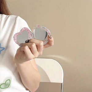 Detail view of heart-shaped Magsafe mirror stand with pink sequins and fold-out design