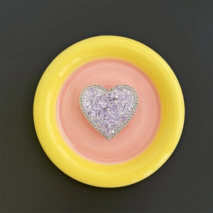 Macro detail of heart-shaped phone grip with purple glitter and white rhinestones