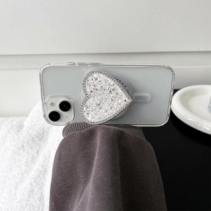 Dettaglio supporto telefono a cuore glitterato su custodia iPhone trasparente