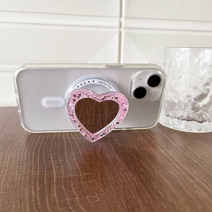 Detail view of pink glitter heart Magsafe phone grip on transparent case with Gift For You text