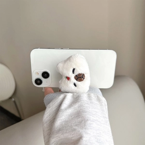 Close-up of cute plush white bear phone grip with strawberry embroidery on smartphone