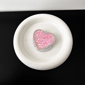 Vista ravvicinata del supporto telefono a cuore glitter rosa con strass e scritte