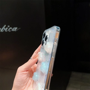 Dettaglio dei motivi a nuvola e paillettes a stella su una custodia per iPhone