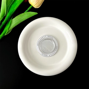 Top-down view of white ceramic tray with silver Gift For You print on black background