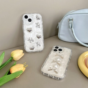 Primo piano di custodie per telefoni color crema con perle, fiocchi e ciondoli.