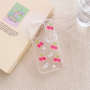 Detail view of iPhone case with 3D cherry, white bowknot, and pearl decorations