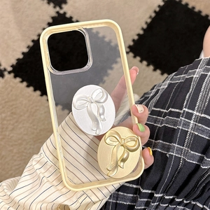 Detail of cream yellow phone case featuring champagne gold and silver bow-knot metal grips