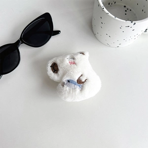 Macro shot of white plush cat earphone case with embroidery and soft faux fur texture