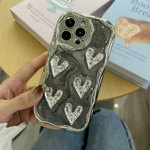 Close-up of the metallic silver wavy edge and resin heart pattern on the iPhone case