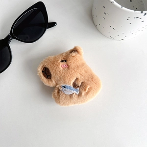 Macro detail of plush capybara phone stand with soft texture and embroidered facial features
