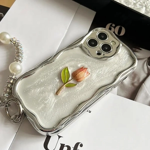 Close-up of silver plated wavy phone case with tulip decor and pearl strap for iPhone