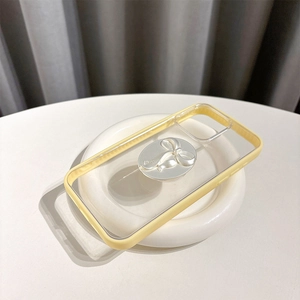 Detail view of transparent phone case with yellow border and silver bow phone grip stand
