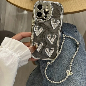 Detailed close-up of electroplated silver heart iPhone case with beaded wrist strap