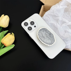 Silver retractable phone socket stand with retro embossed texture and metal frame
