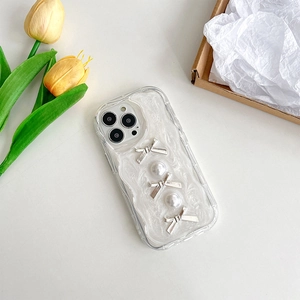 Dettaglio custodia iPhone color crema con fiocchi argentati e perle