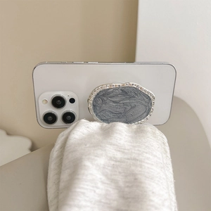 Detail of silver marble phone socket grip showing premium texture and metallic edge