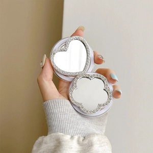 Detail view of heart and flower-shaped foldable mirrors with sparkling rhinestone edges