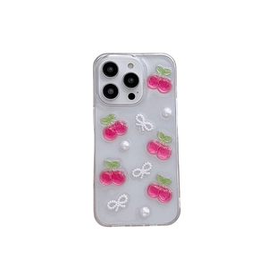 Clear iPhone case with pink cherries, pearl bowknot, and glitter accents on white background