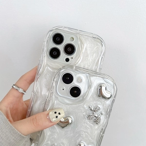 Primo piano della custodia per iPhone in madreperla bianca con ciondoli a cuore e cane