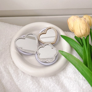 Close-up of rhinestone heart and clover-shaped phone grips with reflective mirrors