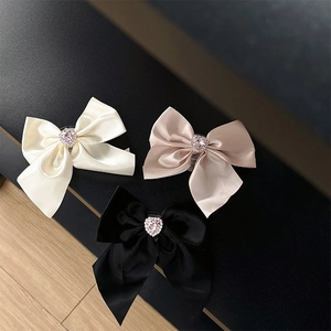 Sparkling rhinestone bow foldable phone grip holder in pink, black, and white satin colors