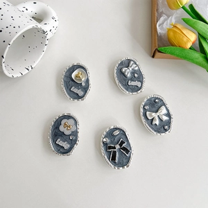 Detailed view of vintage-style oval phone grips with Luck text and 3D bow accents