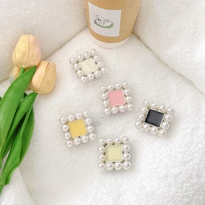 Square pearl phone socket stand in assorted colors on soft white plush background