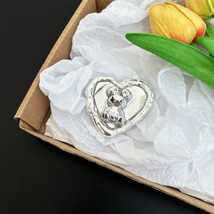 Detailed macro view of silver heart-shaped phone grip with 3D bear design in gift box