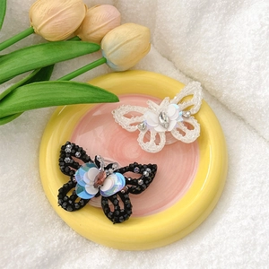 Detailed view of sequined butterfly phone grip set with lace and beads on display tray