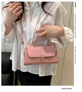 Detail of pink matte leather handbag with gold vertical clasp and sleek shoulder strap