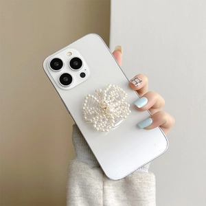 Close-up of pearl butterfly grip-tok on a minimalist white phone case hand-held detail