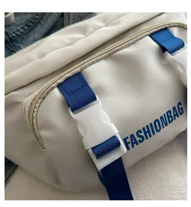Detail of white nylon crossbody bag with blue strap and plastic buckle fastening