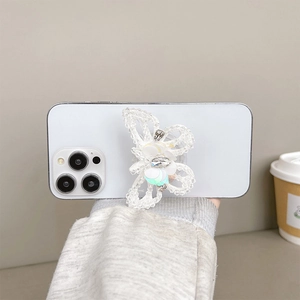 Close-up of a sparkling butterfly phone grip with white sequins and rhinestones on a device