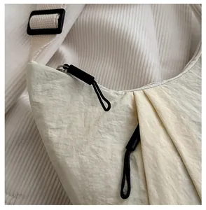 Détail de la fermeture éclair noire et de la texture en nylon sur un sac fourre-tout beige