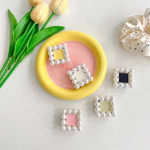 Macro detail of square pearl phone grip stands with colorful enamel inlay for mobile devices