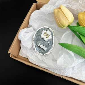 Detail of grey marble effect phone grip with golden bow, white flower and Lucky lettering