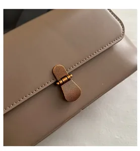 Detail van tan lederen kleptas met vintage bronzen metalen draaisluiting