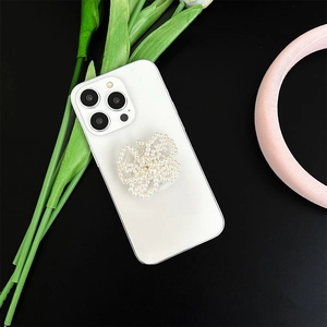 Top view of a butterfly-shaped pearl phone socket mount on a white smartphone back