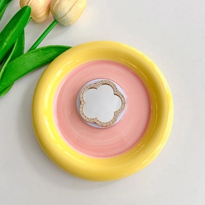 Detailed close-up of a floral rhinestone phone mirror socket on a pastel dish