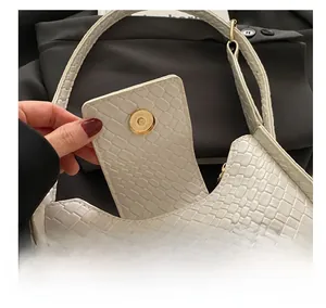 Gros plan d'un sac à main blanc en cuir embossé avec texture tressée et fermoir magnétique doré