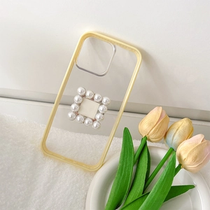 Detail of clear iPhone case with yellow edges and square pearl phone grip decoration