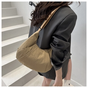 Detail of khaki nylon dumpling bag with adjustable strap and waterproof hobo design