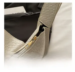Détail de la texture tressée et fermeture éclair dorée sur sac à bandoulière crème