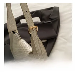 Détail macro du sac bandoulière beige avec boucle en métal doré réglable et cuir