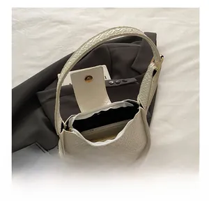 Vue intérieure du sac bandoulière blanc à motif croco montrant sa capacité et sa poche