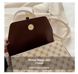 Detail view of the vintage monogram handbag featuring a gold hardware magnetic snap closure