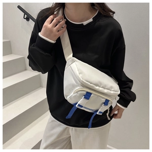 Close-up of white nylon chest bag with blue buckle detail and adjustable strap