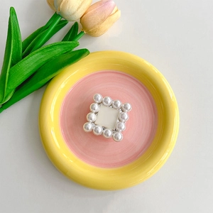 Detailed view of pearl square phone grip centerpiece with gold metal base and ivory beads