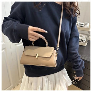 Detailed view of beige crossbody bag with golden metal buckle and adjustable strap