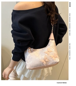 Détail du sac hobo en dentelle rose avec broderie papillon 3D et bandoulière chaîne